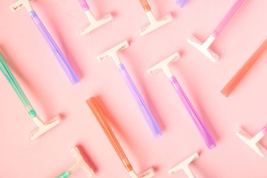 Pembe arka planda farklı jiletler, yakın plan.