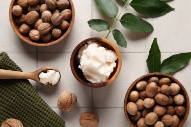 Beyaz fayanslı fındıklı kase ve kaşık dolusu Shea yağı.