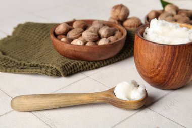 Beyaz fayanslı fındıklı bir kase dolusu Shea yağı.