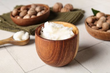Beyaz fayanslı fındıklı bir kase dolusu Shea yağı.