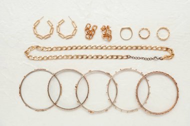 Aydınlık arka planda farklı tarz kadın mücevherleri.