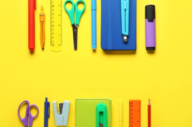 Sarı arka planda okul malzemelerinden yapılmış çerçeve. Üst görünüm