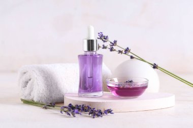 Havlu, alçı standı, şişe ve bir kase hafif arka planda gerekli lavanta yağı.