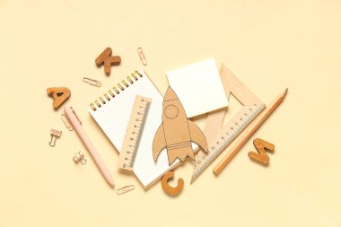 Bej arka planda farklı okul kırtasiyesine sahip karton roket.
