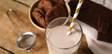 Tahta masada bir bardak çikolatalı süt, yakın plan.