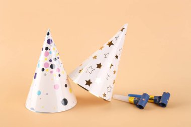 Renkli arka planda ıslık çalan parti şapkaları