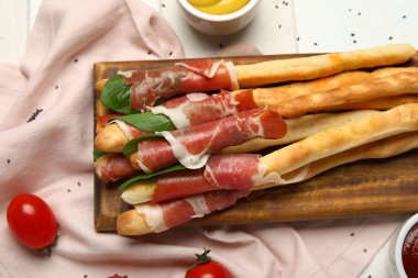 Sofrada pastırmalı lezzetli İtalyan Grissini tahtası, yakın plan.