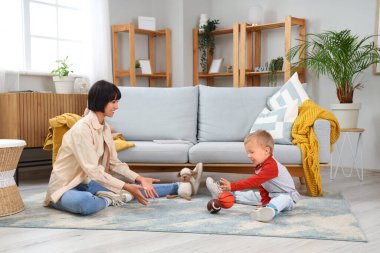 Genç anne ve küçük oğlu evde top oynuyorlar.