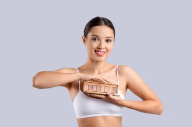 Işık arka planında göz farı olan genç Asyalı kadın.