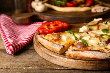 Lezzetli pizzalar, dolma biber dilimleri ve ahşap arka planda peçete.