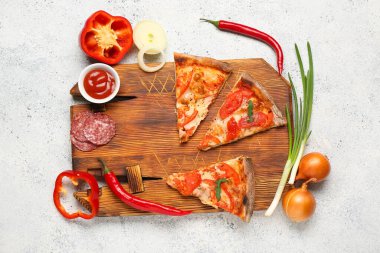 Lezzetli pizza dilimleri, malzemeler ve beyaz grunge arka planda bir kase sosla ahşap tahta.