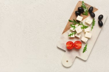 Beyaz arka planda peynirli, roka, vişneli domates ve zeytinli pano.