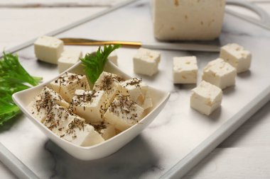 Beyaz ahşap arka planda beyaz peynirle servis ve kase.