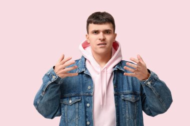 Young deaf mute man using sign language on pink background clipart