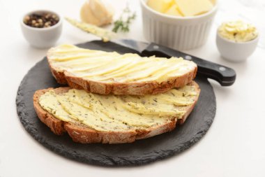 Beyaz arka planda taze tereyağlı siyah ekmek dilimleri.