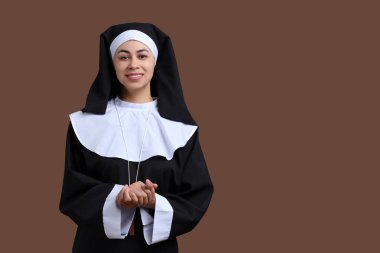 Kahverengi arka planda genç bir rahibenin portresi