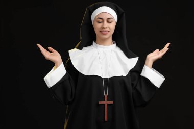 Siyah arka plandaki genç rahibe.