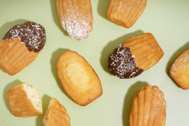 Çikolatalı, pudra şekerli ve yeşil arkaplanlı hindistan cevizli leziz kurabiyeler.