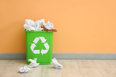 Bej duvarın yanında kağıt olan geri dönüşüm kutusu. Geri dönüşüm kavramı