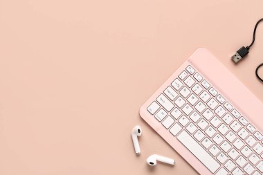 Kulaklık, kablo ve bilgisayar klavyelerini pembe arka planda şarj etmek. Üst görünüm