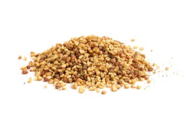 Beyaz zemin üzerinde çiğ karabuğday taneleri yığını