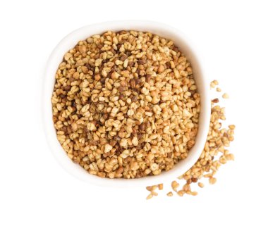 Beyaz arkaplanda çiğ karabuğday taneleri olan kase