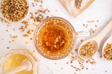 Hafif arka planda bir bardak taze karabuğday çayı, yakın plan.