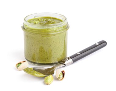 Kavanozda fıstık ezmesi ve beyaz arka planda kaşık.