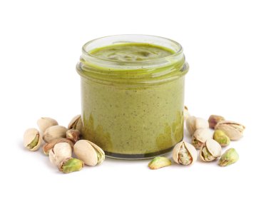 Beyaz arka planda kavanoza fıstık ezmesi.