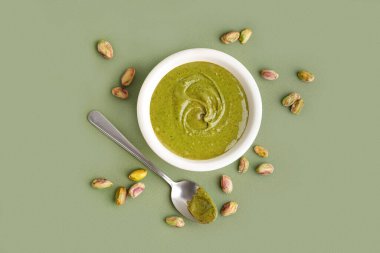 Fıstık ezmeli kase ve yeşil arka planda kaşık.