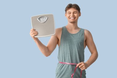 Pulları olan ve arka planda şerit bulunan genç bir sporcu. Kilo verme konsepti