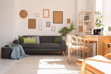 Siyah kanepesi, çiçekleri ve resimleri olan şık bir oturma odası.