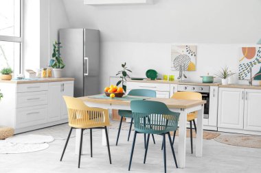 Masada turunçgiller olan beyaz mutfağın içi.