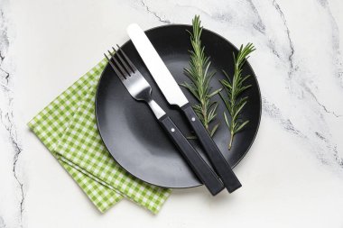 Beyaz grunge arka planda peçete, çatal bıçak ve biberiye ile modern masa ayarları