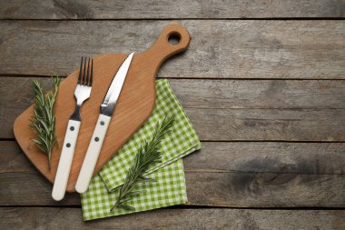 Tahta, peçete, çatal bıçak takımı ve ahşap arka planda biberiye ile modern masa ayarları