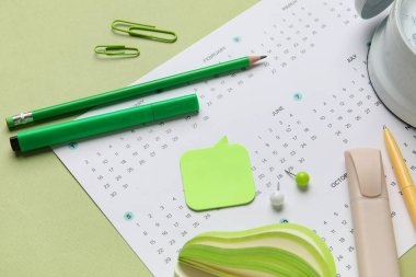 Yeşil arkaplanda ofis kırtasiyesiyle takvim