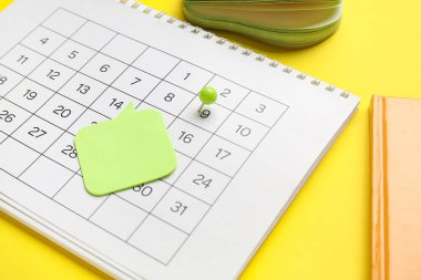 Sarı arkaplanda ofis kırtasiyesiyle takvim