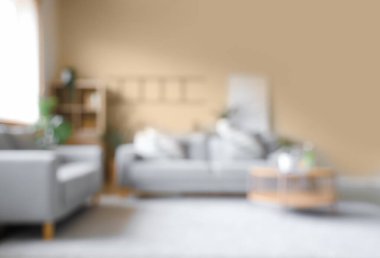 Oturma odasının bulanık manzarası, kanepeler ve masa.