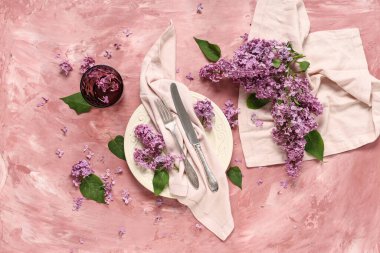 Pembe grunge arka planında leylak çiçekleri olan güzel bir masa.