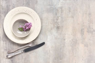 Açık grunge arkaplan üzerinde leylak çiçekleri ile güzel masa ayarları