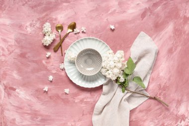 Pembe arkaplanda beyaz leylak çiçekleri olan güzel bir masa.