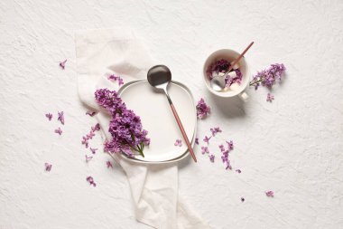 Beyaz grunge arkaplan üzerinde leylak çiçekleri ile güzel masa ayarları