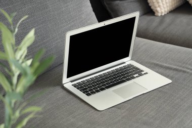 Modern laptop siyah kanepede oturma odasında, yakın plan.