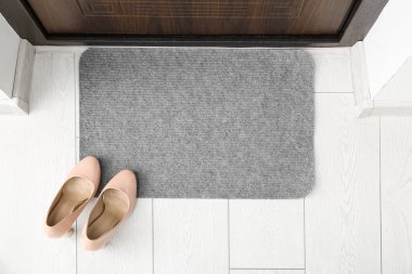 Gri kapı paspası. Koridordaki beyaz zemin.