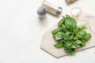 Beyaz arka planda taze yeşil fesleğen yaprakları olan tahta