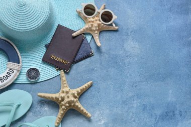 Pasaport, plaj aksesuarları ve mavi grunge arka planda deniz yıldızları.