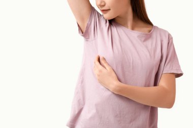 Beyaz arka planda göğüslerini kontrol eden genç bir kadın.