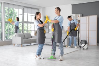 Genç hademeler odada birbirlerine beşlik çakıyorlar.