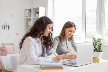 Yurt odasındaki masada çalışan kız öğrenciler