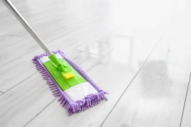 Evde bej ahşap zemini paspasla temizliyorum.